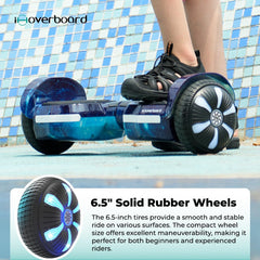A person is riding a blue hoverboard H2 with 6.5-inch solid rubber wheels, featuring illuminated wheel designs. The background shows a tiled wall, and the hoverboard is on a smooth surface.