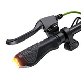 A black scooter S10max handlebar with a textured grip features an integrated brake lever, a glowing orange light at the end, and a control switch with arrow symbols, all connected by a green cable.