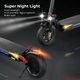 A black electric scooter ix4 is shown with bright front headlights, yellow side signal lights, and a red brake light, highlighting its night visibility features.