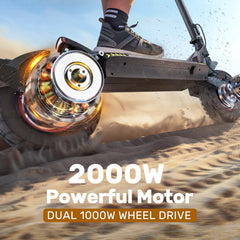 A powerful electric scooter ix7pro with dual 1000W wheel drive is shown speeding across sandy terrain, kicking up dust. The close-up view highlights the dynamic motion of the wheels and the rider's sneakers.