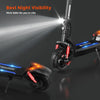A black electric scooter gt2 with rugged tires is shown, featuring bright front and rear lights for enhanced night visibility. The scooter has red suspension components and a glowing blue logo on the deck, set against a dark background.