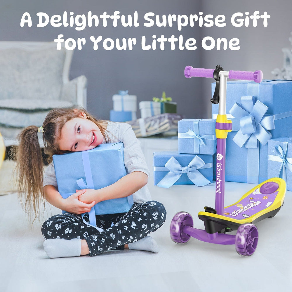 A smiling young girl sits on the floor, hugging a blue gift box with a ribbon, surrounded by more wrapped presents. Beside her is a colorful children's scooter minispider with purple wheels and a yellow deck. The scene conveys a sense of joyful surprise.