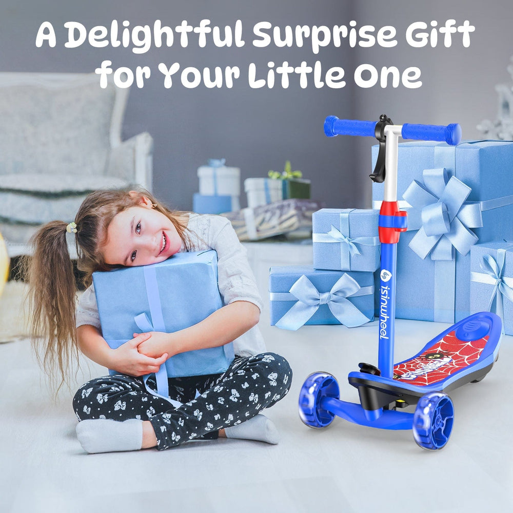 A young girl joyfully hugs a blue gift box while sitting on the floor, surrounded by more blue presents with ribbons. Beside her, a colorful children's scooter minispider with blue handlebars and wheels is prominently displayed.