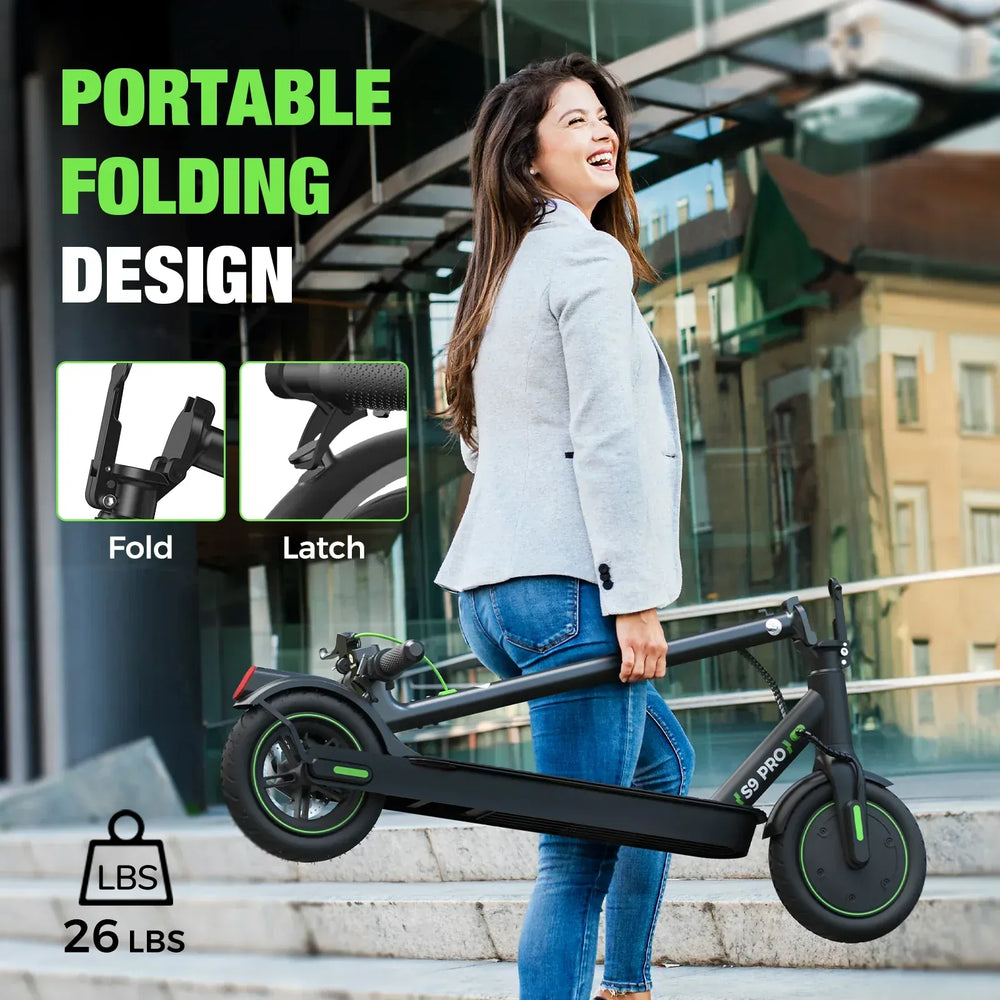 A woman in a light gray blazer and jeans is joyfully carrying a black folding electric scooter up concrete steps, with a glass building in the background. The scooter is labeled "S9 PRO" and weighs 26 lbs, featuring a portable design with fold and latch mechanisms highlighted.