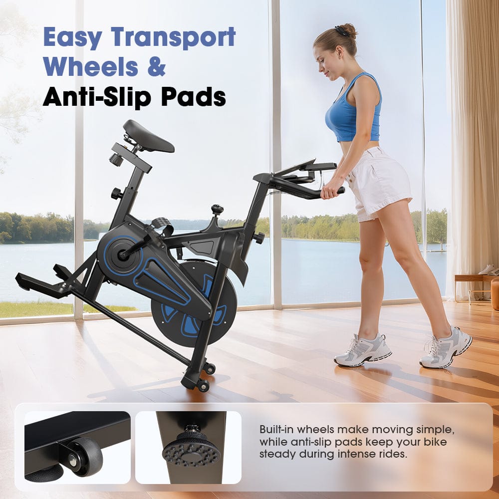 A woman in workout attire is easily moving a stationary bike QK116C with built-in wheels across a sunlit room with large windows overlooking a lake. The bike features blue accents, and the inset images highlight the transport wheels and anti-slip pads for stability.