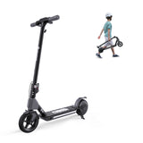 A sleek black electric scooter S4 stands upright, featuring a modern design with a sturdy frame and visible branding. In the background, a child wearing a helmet and striped shirt walks while carrying a folded version of the scooter, showcasing its portability.