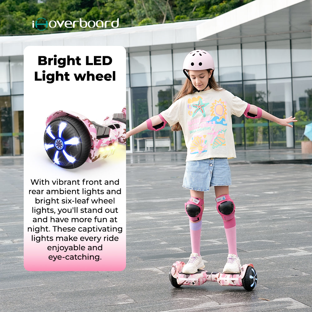 A girl wearing a helmet enjoys the iHoverboard Hoverboard for Kids Aged 6+, featuring self-balancing, Bluetooth, and bright LED 6.5" wheels—ideal for safe night riding on paved surfaces.
