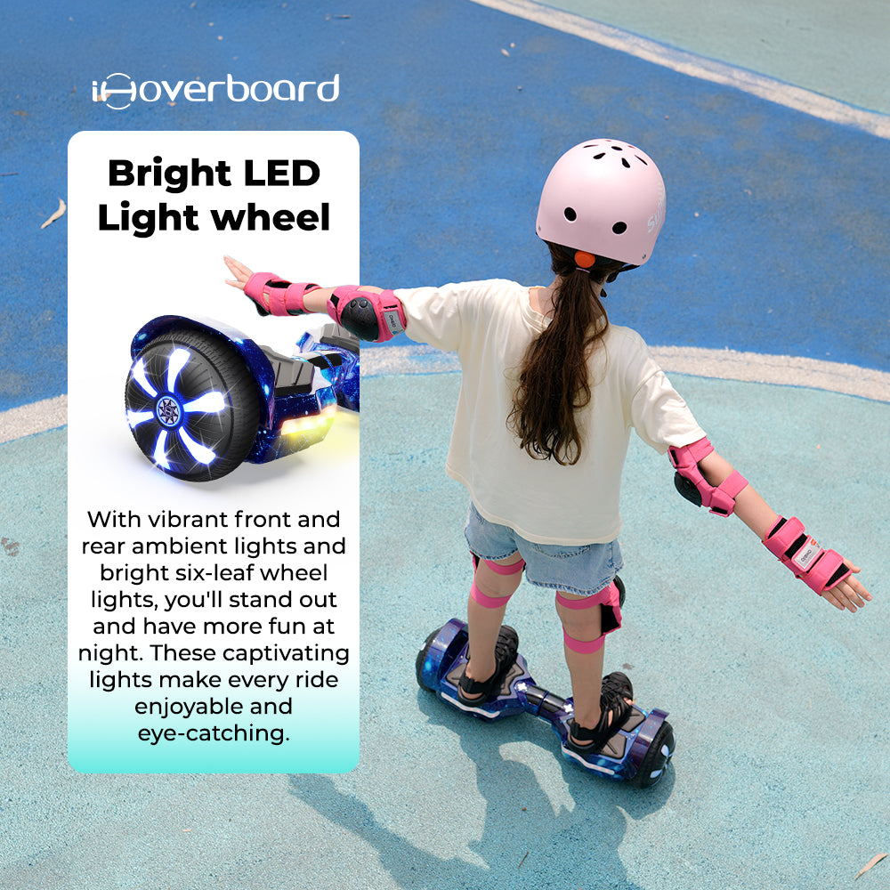 A child in a pink helmet rides the iHoverboard Hoverboard for Kids Aged 6+ (Self Balancing, Bluetooth & LED 6.5"-H2), featuring bright LED wheel lights that make riding more fun and eye-catching on a blue outdoor surface.