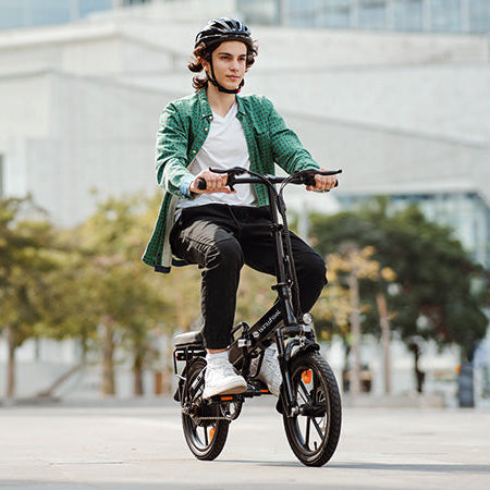 Person riding a small electric bike on a city street