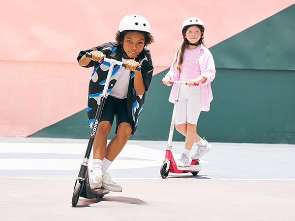 Two friends riding iScooter IK1S electric scooters side by side, showcasing the scooters' stable performance