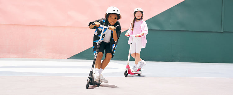 In different colours, two friends are riding iScooter IK1S electric scooters together.