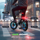 Person riding an electric bike with dual brakes and rear lights on a city street at night.