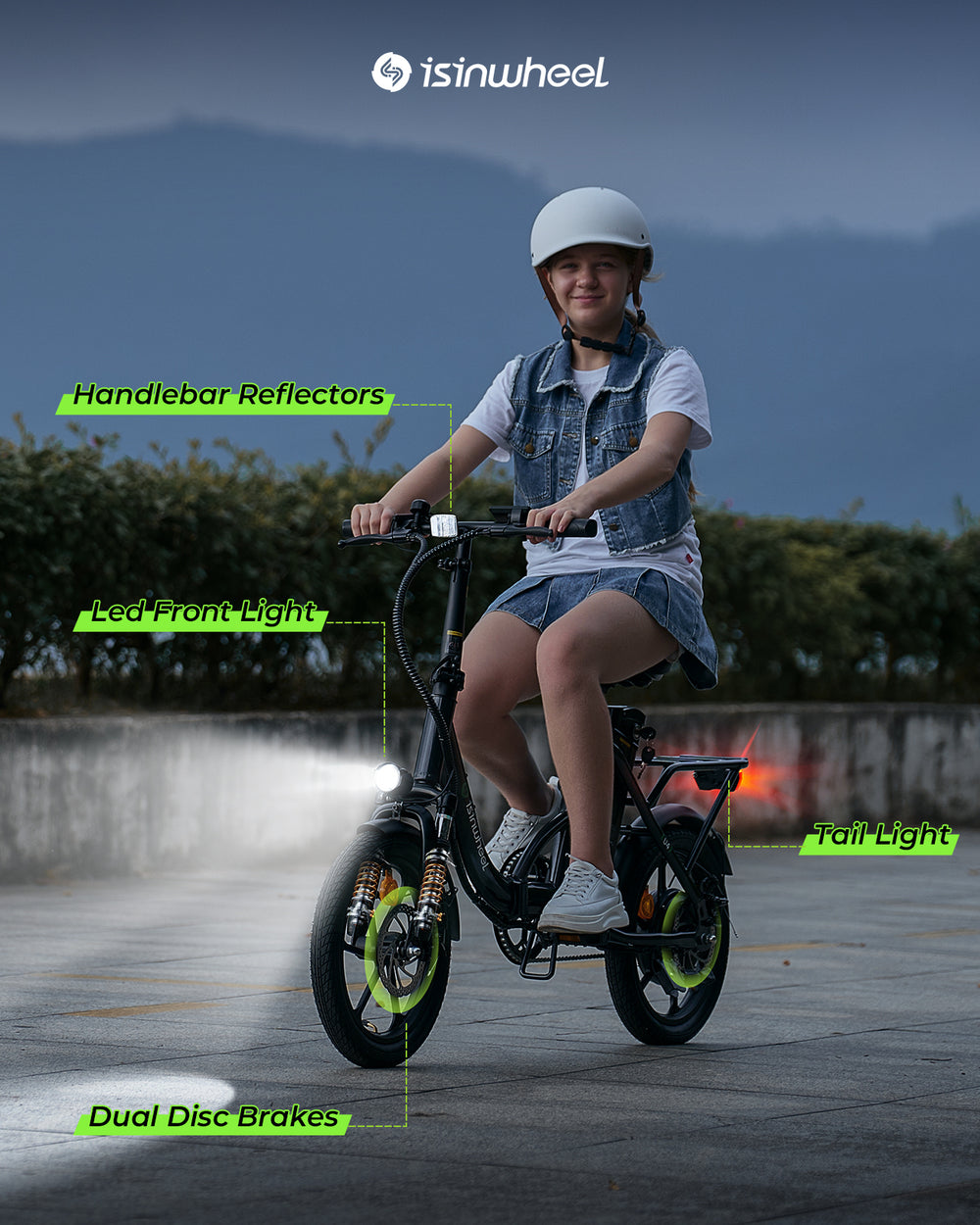 A teen riding a bicycle at night with highlighted features, featuring the isinwheel brand,dual disc brakes, dual led lights