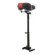 A scooter seat with a black and red cushioned saddle is mounted on a tall, adjustable black post with a sturdy base.