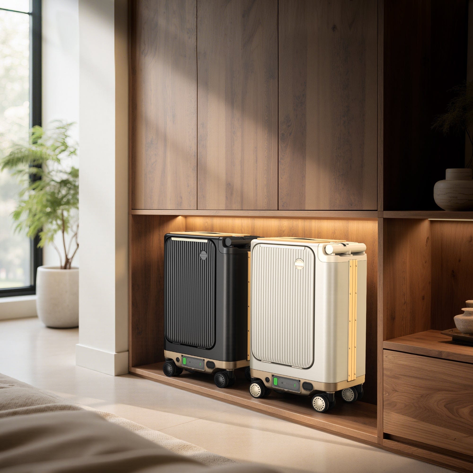 Two modern suitcases, one black and one cream, are stored in a wooden shelving unit with warm lighting. A potted plant is visible near a large window in the background.