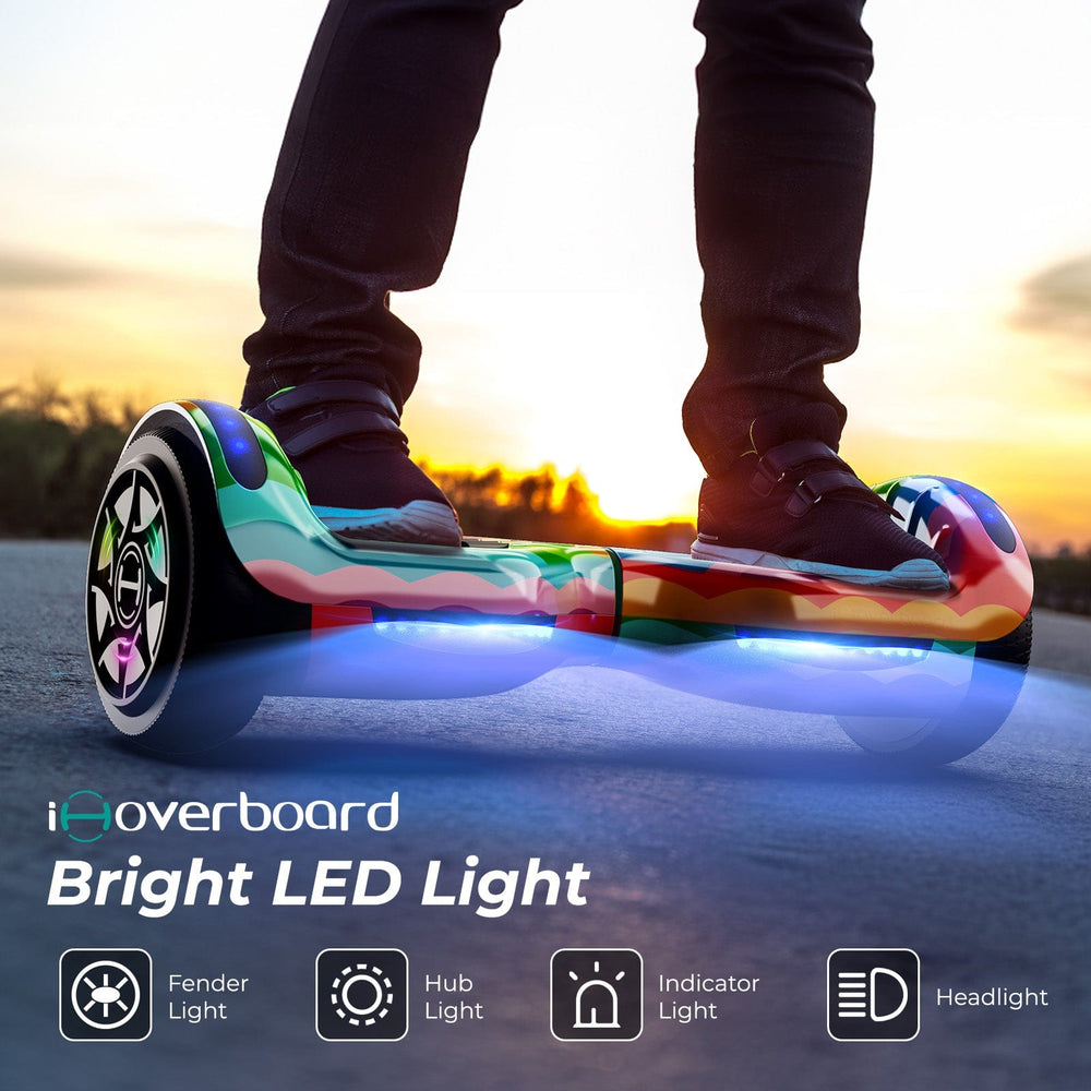 At sunset, a person rides the iHoverboard Hoverboard for Kids, 6.5" Self-Balancing H1 with Bluetooth and vibrant LED lights, featuring fender light, hub light, indicator light, headlight, and CE certification.