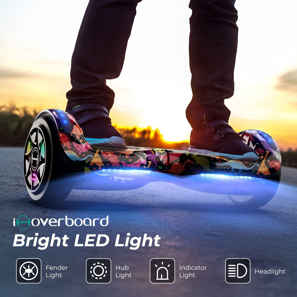 A person rides the iHoverboard Hoverboard for Kids, 6.5" Self-Balancing with Bluetooth LED lights at sunset. Features include fender light, hub light, indicator light, and headlight. CE Certified-H1.